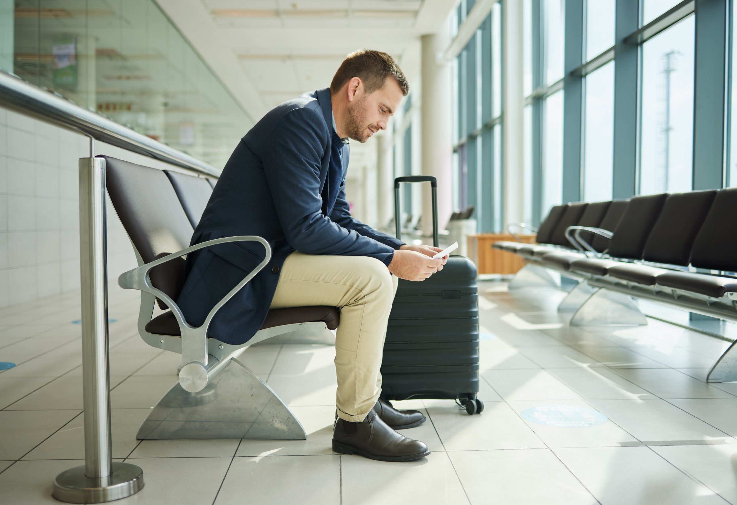 Ticket, airport and business man in waiting room travel, global opportunity and transport time or schedule. UK employee, entrepreneur or corporate person in lobby